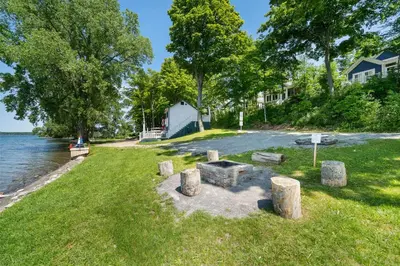 a picnic area on the shore of a lake with trees at The Kiskadee - 49 Butternut in Cherry Valley