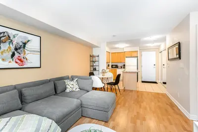 a living room with a couch and a kitchen at High-End 2BR 2BATH Condo-Steps to Square One Mall in Mississauga