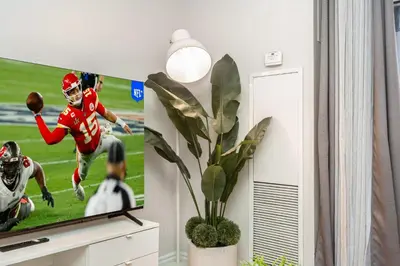 a tv in a living room with a football game at High-End 2BR 2BATH Condo-Steps to Square One Mall in Mississauga