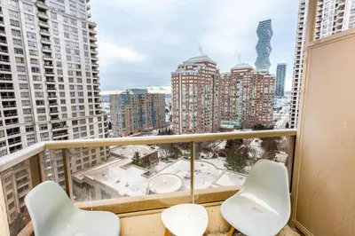 a balcony with two chairs and a view of the city at High-End 2BR 2BATH Condo-Steps to Square One Mall in Mississauga