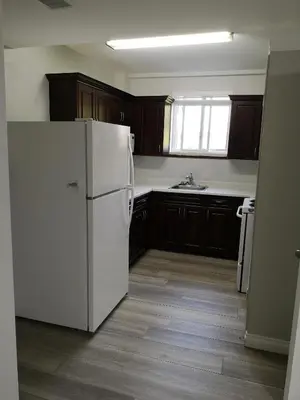 a kitchen with a white refrigerator and wooden cabinets at Cozy in London