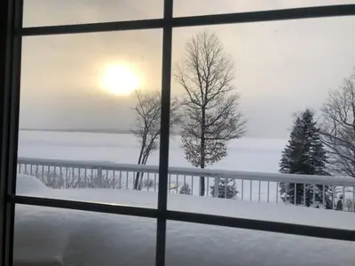 a view from a window of a snow covered field at Cottage apartments at Lake Huron in Midland