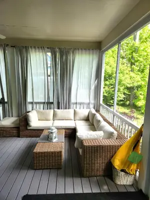 a living room with a couch on a porch at L'Hibou - 18 Farm View in Cherry Valley