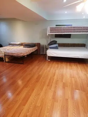 a room with two bunk beds and a wooden floor at Large Guest suite with bathroom, vegetarian kitchen in Mississauga