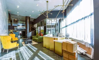 a lobby with yellow furniture and a large window at Stunning new condo in Oakville in Oakville