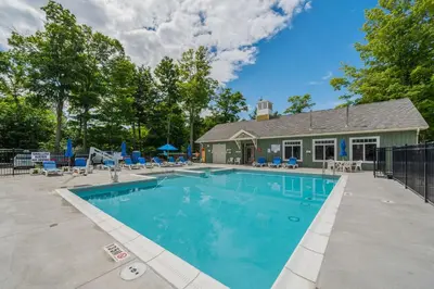 a swimming pool in front of a house at The Trillium - 2 Pine Forest in Cherry Valley