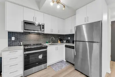 a kitchen with white cabinets and a stainless steel refrigerator at Luxury Spacious Apartment 10 min to Airport Wifi in Brampton