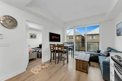 a living room with a couch and a table with chairs at Luxury Spacious Apartment 10 min to Airport Wifi in Brampton