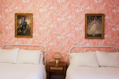 two beds in a bedroom with pink wallpaper at Comfy Waterfront Suite 2 Double Beds Ensuite in Belleville