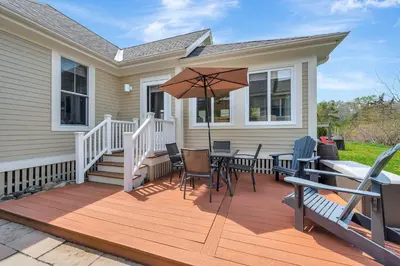 a wooden deck with a table and an umbrella at 93 Butternut in Cherry Valley