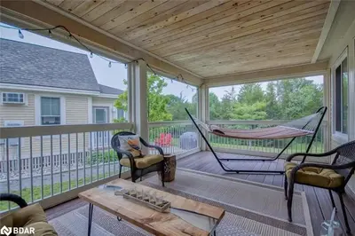 a porch with a hammock and a table and chairs at 93 Butternut in Cherry Valley