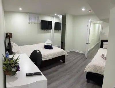 a hotel room with two beds and a table and a room at B02 luxurious suite in Mississauga