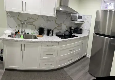 a white kitchen with a sink and a refrigerator at B02 luxurious suite in Mississauga