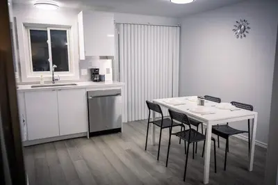 a kitchen with a table and chairs and a sink at Cozy Barrie Home - Minutes to College & Hospital in Barrie