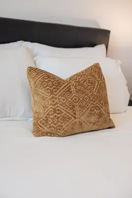 a pillow sitting on a bed with white pillows at Luxury Living 5 mins from the Falls in Niagara Falls