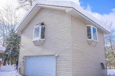 a house with a garage door and two windows at Lake View Loft in Severn
