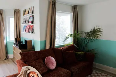 a living room with a brown couch and a window at Large Waterfront Home w 5 Ensuite Bathrooms in Belleville