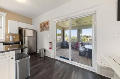 a kitchen with a sliding glass door to a deck at The Marmot - 12 Butternut in Cherry Valley