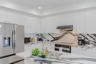 a kitchen with white cabinets and a stainless steel refrigerator at Amazing Home in Niagra Region in Thorold