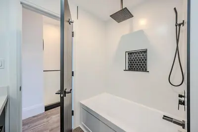 a white bathroom with a shower and a sink at Charming 2 Bed Apartment in Cambridge
