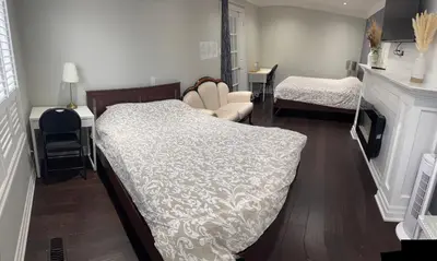 a bedroom with a bed and a couch and a fireplace at F3 Spacious room with 2 queen beds and TV in Mississauga