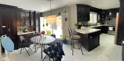 a kitchen with a table and chairs and a kitchen with a counter at F1 cozy Sunny room in Mississauga
