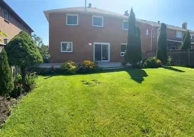 a house with a yard with a grass yard at F1 cozy Sunny room in Mississauga
