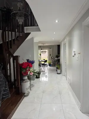a hallway of a house with a staircase and flowers at F1 cozy Sunny room in Mississauga