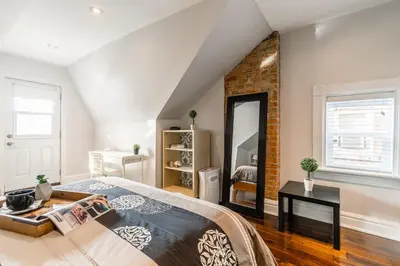 a bedroom with a bed and a brick wall at Modern City Suite with Rooftop Patios in Toronto