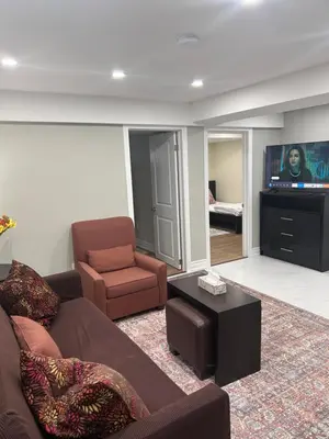 a living room with a couch and a chair and a television at Private 2bedroom Unit, Free Parking, Free from Smoke & Pet, Self-Check IN in Pickering