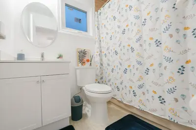 a white bathroom with a toilet and a mirror at Spacious 4 bedroom Home - 15 mins from YYZ airport in Mississauga