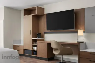 a room with a desk with a television and a chair at Hyatt Place Mississauga / Airport Corp Center in Mississauga