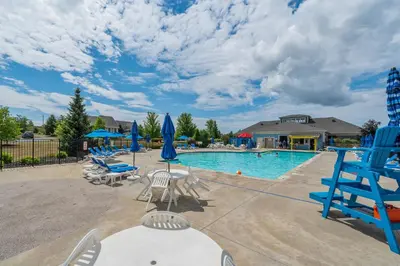 a swimming pool with chairs and blue chairs at The Amanita - 9 Hollow in Cherry Valley