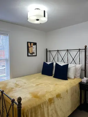 a bedroom with a large bed with blue pillows at St Catharines Niagara Escape in St. Catharines