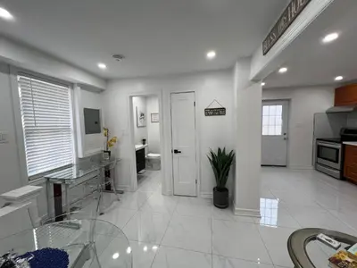a large kitchen with white walls and white tile floors at St Catharines Niagara Escape in St. Catharines