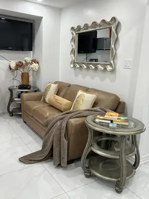 a living room with a couch and a table with a mirror at St Catharines Niagara Escape in St. Catharines