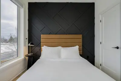 a bedroom with a large white bed and a window at The Luxury Black Rose Chalet at The Blue Mountains for 20 in Blue Mountains