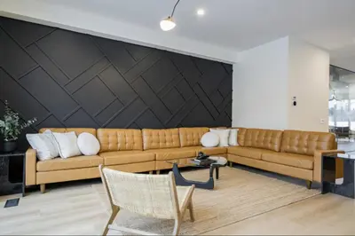 a living room with a brown couch and a black wall at The Luxury Black Rose Chalet at The Blue Mountains for 20 in Blue Mountains