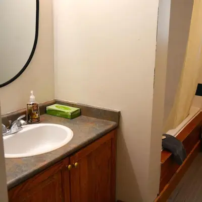 a bathroom with a sink and a mirror and a tub at The Blue Mountains Chalet for 20- 8BR Bliss w Hot Tub in Blue Mountains