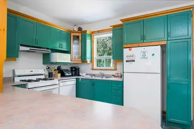 a kitchen with green cabinets and a white refrigerator at The Four Leaf Clover at The Blue Mountains for 12 in Blue Mountains