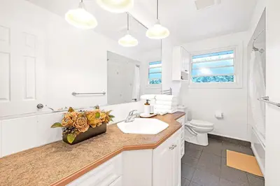a white bathroom with a sink and a toilet at Luxury Old Town Winter Retreat- Hot Tub and Games in Niagara on the Lake