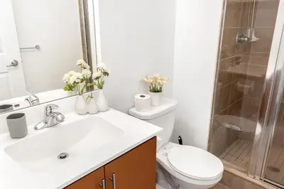 a bathroom with a toilet and a sink and a shower at Luxurious 2BR 2BATH Condo Steps from Square One in Mississauga