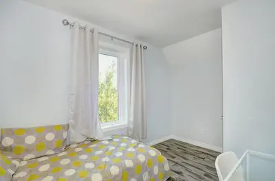 a bedroom with a couch and a window at Luxurious Condo with Balcony in Kitchener in Kitchener