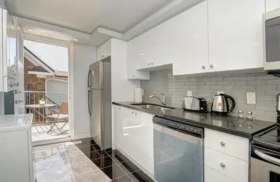 a kitchen with white cabinets and a counter top at Luxurious Condo with Balcony in Kitchener in Kitchener