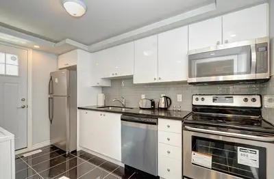 a kitchen with white cabinets and a stainless steel appliance at Luxurious Condo with Balcony in Kitchener in Kitchener