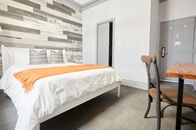 a bedroom with a bed and a desk and a chair at La TUMU in Toronto