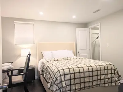 a bedroom with a bed with a checkered blanket at Kings Palace Basement in Brampton