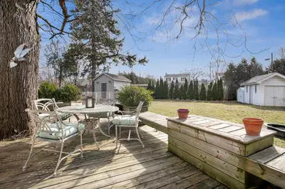 a wooden deck with a table and chairs on it at Stylish 3br Home, Close To Restaurantsshops in Mississauga