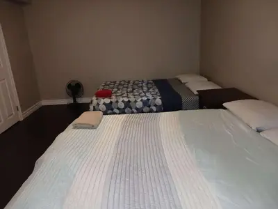 two beds in a small room with at Kitchener -WLU BNB-Minutes To University of Waterloo, Conestoga College,Buses,Airport in Waterloo