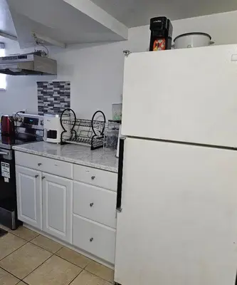 a kitchen with a white refrigerator and a stove at Queen bedroom in Toronto
